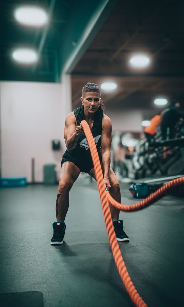 Man performing an intense battle-rope training session